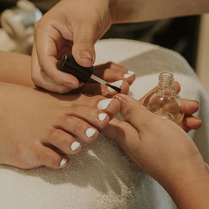 Auftragen von weißem Nagellack bei einer Pediküre